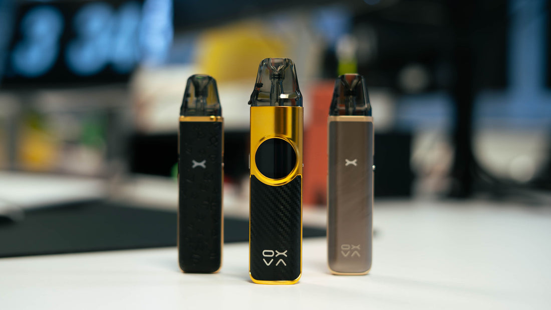 Three Oxva Xlim vaping devices on a table.