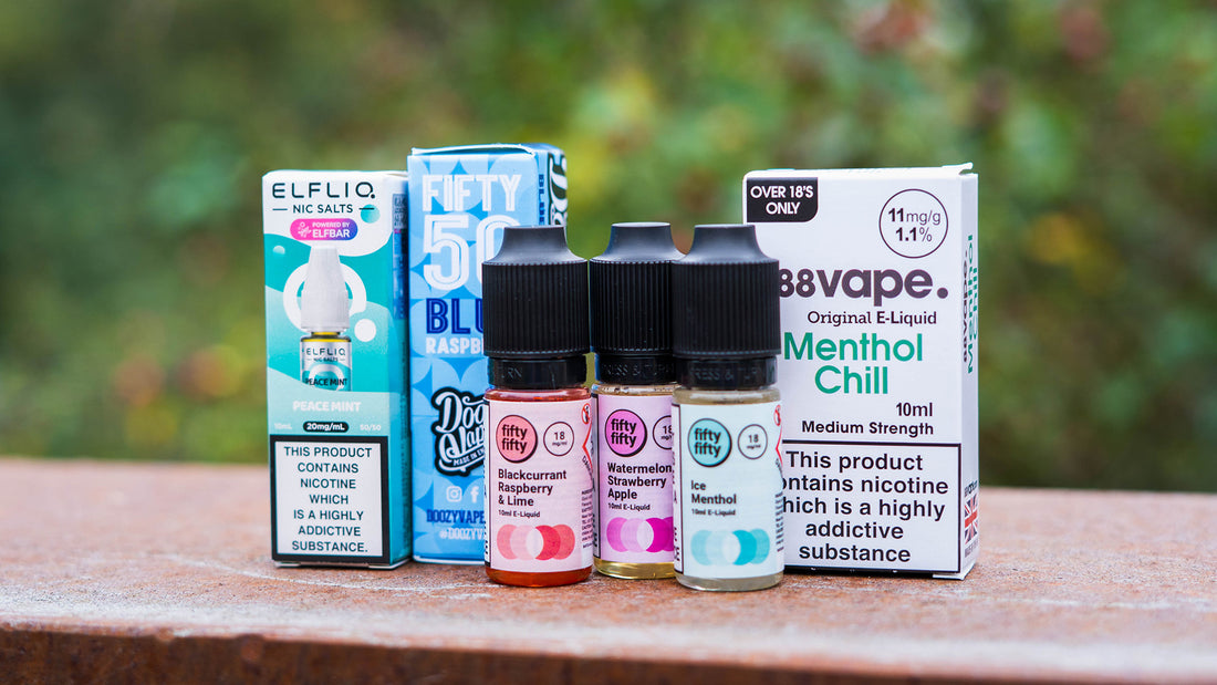 Bottles of vape juice arranged in front of colorful packaging.